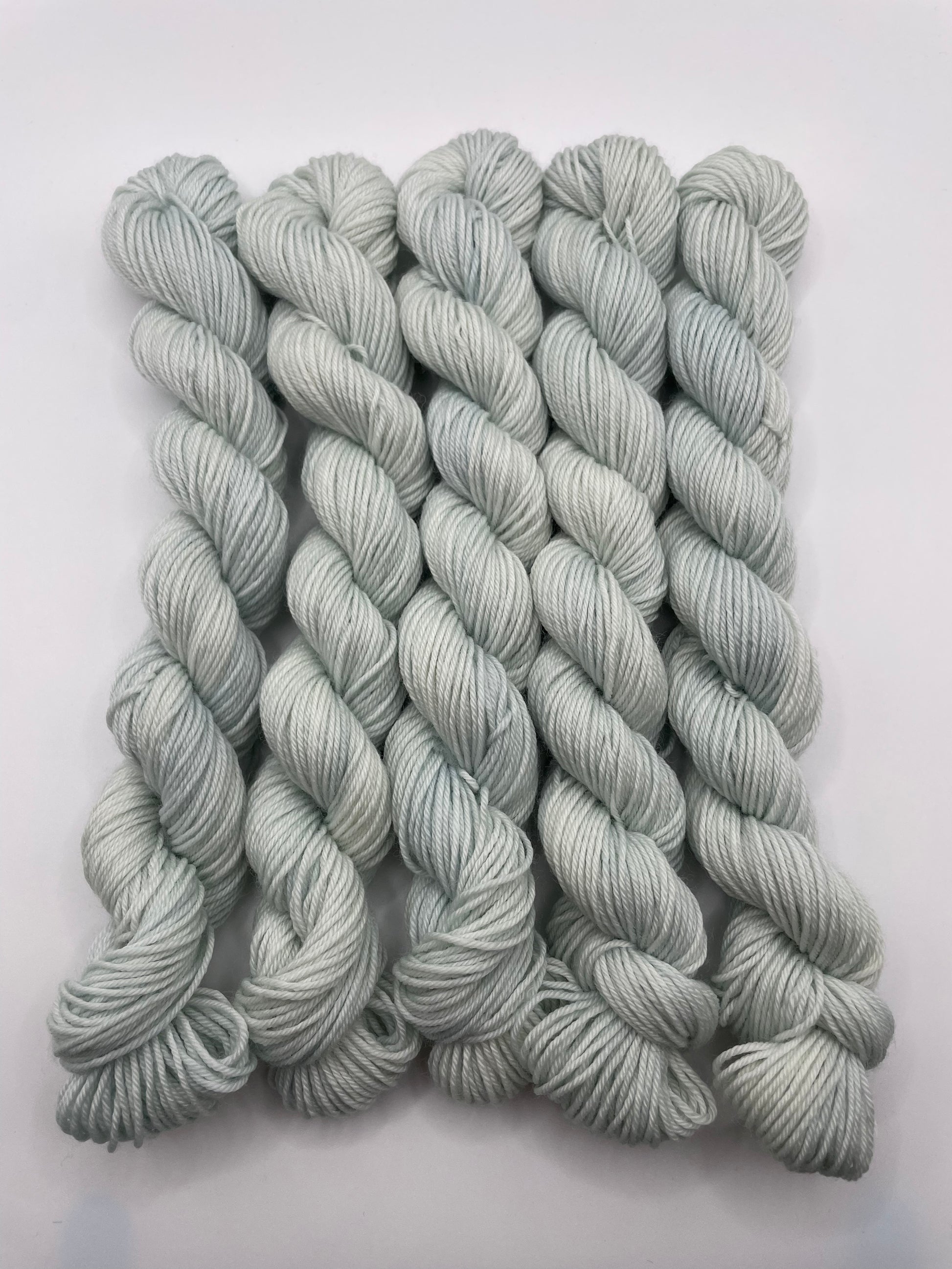 Pale mint mini skeins on a white background