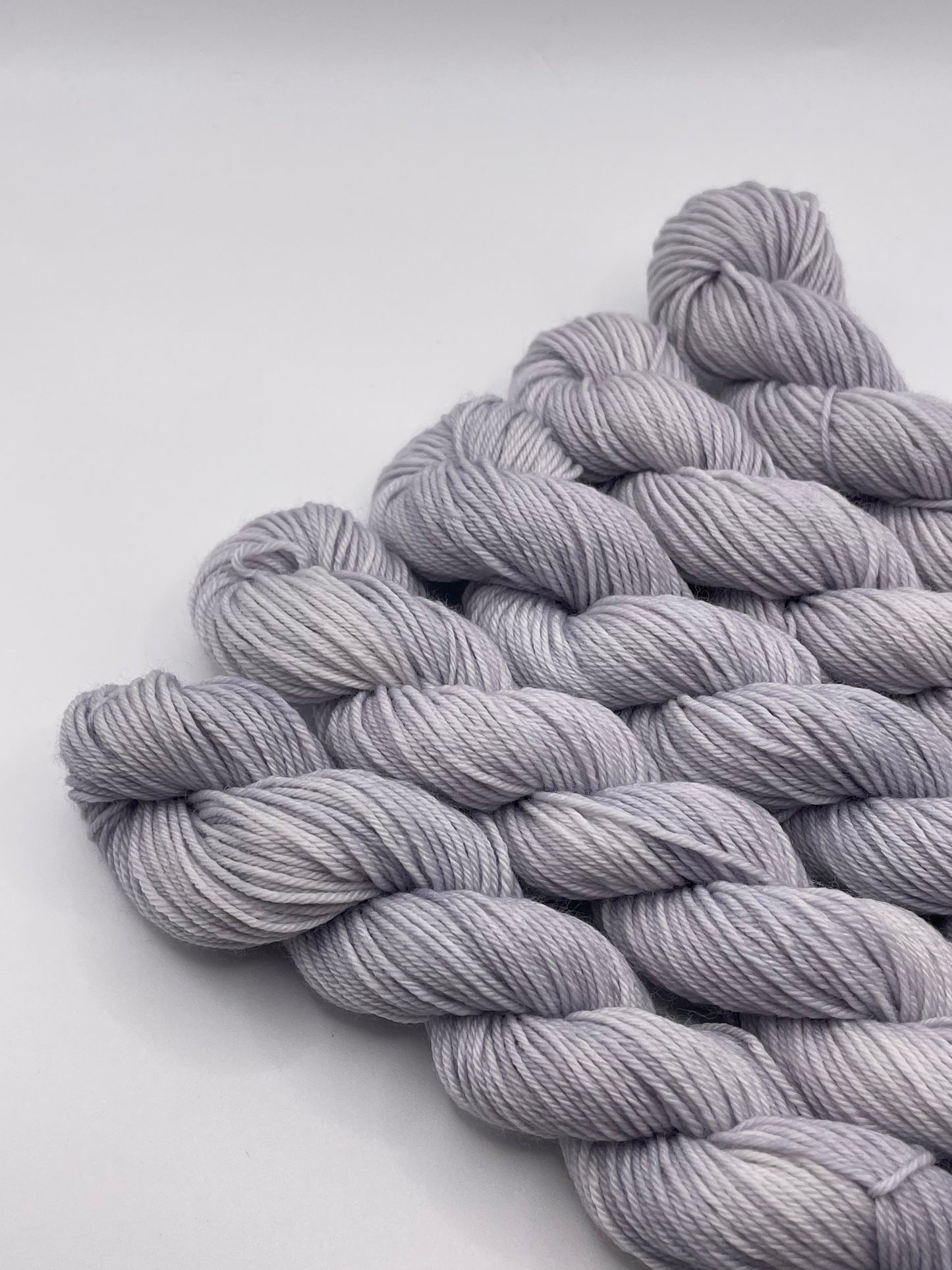 Grey yarn mini skeins on a white background