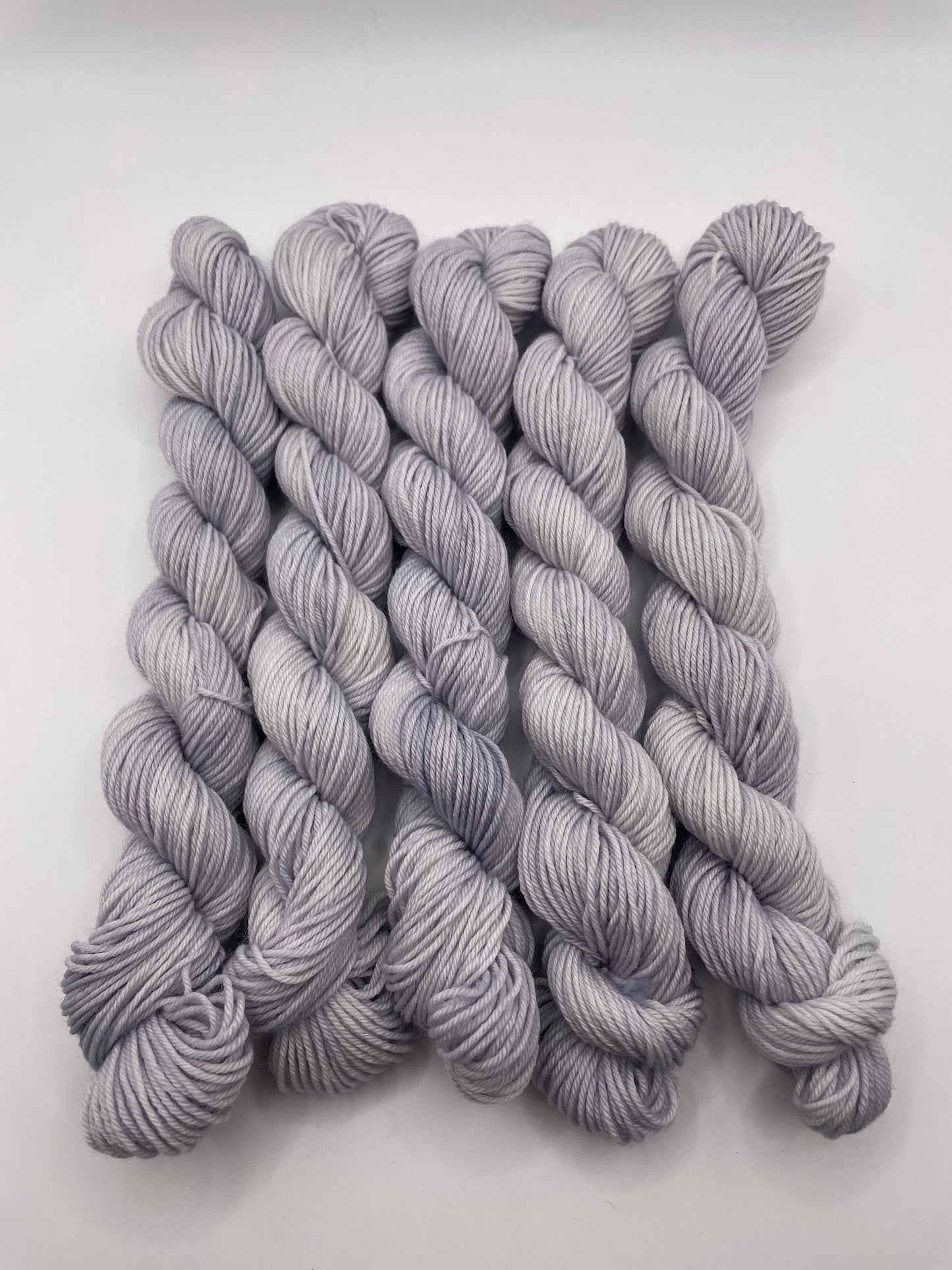 Grey yarn mini skeins on a white background