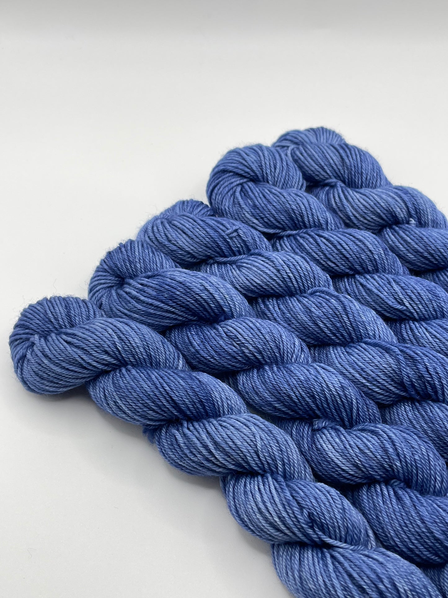 Deep blue yarn mini skeins on a white background