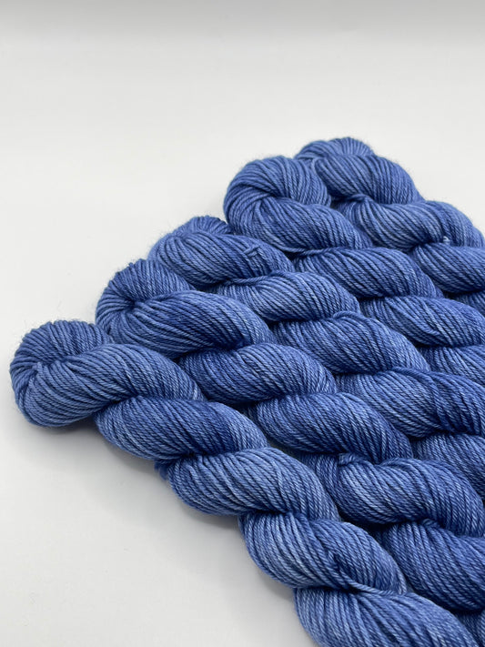 Deep blue yarn mini skeins on a white background