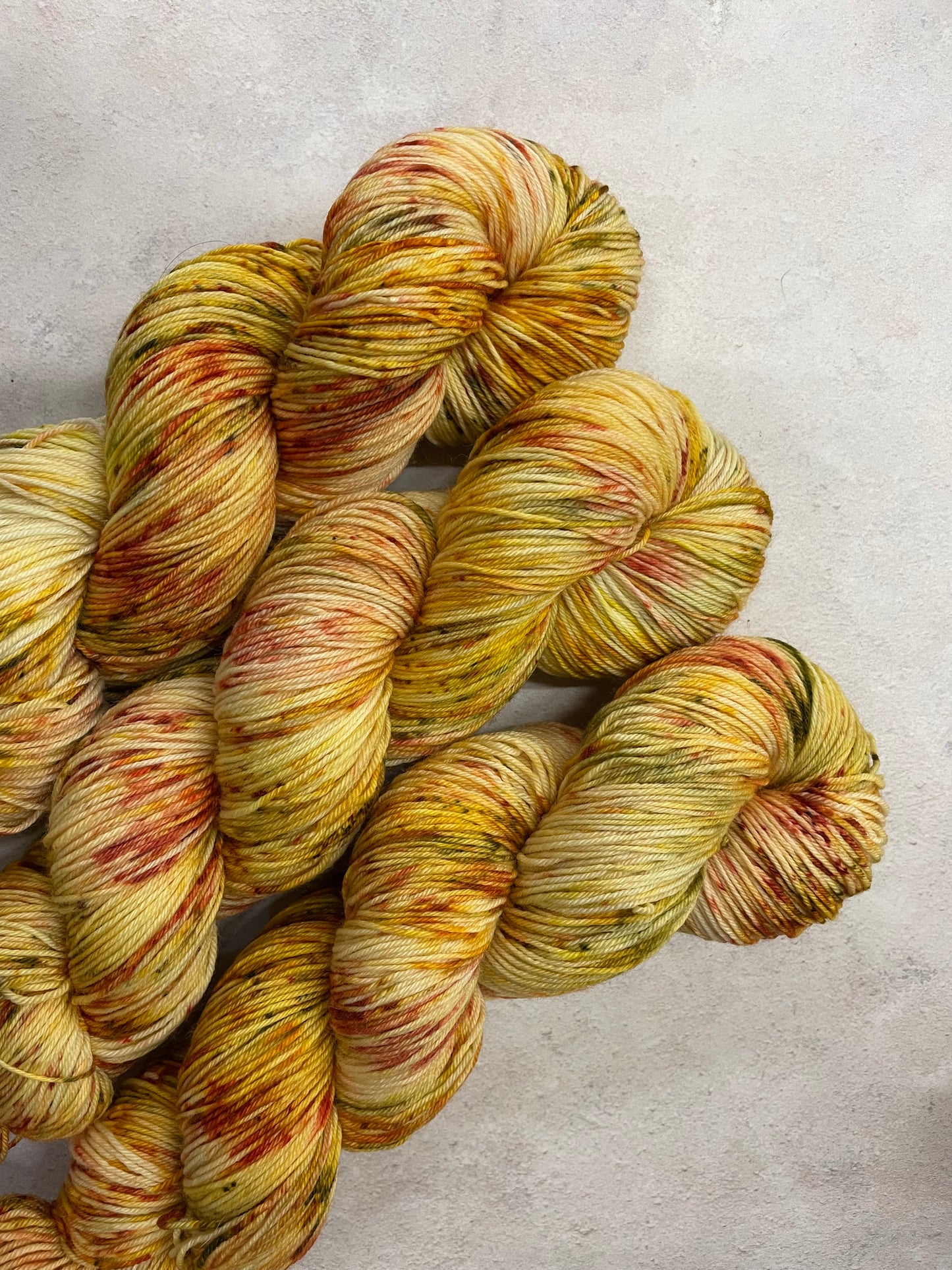 3 skeins of yellow yarn with gold, red and green speckles