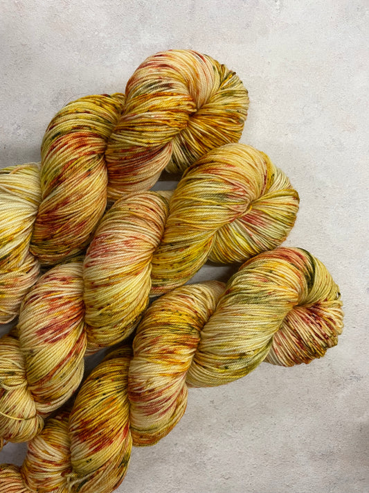 3 skeins of yellow yarn with gold, red and green speckles