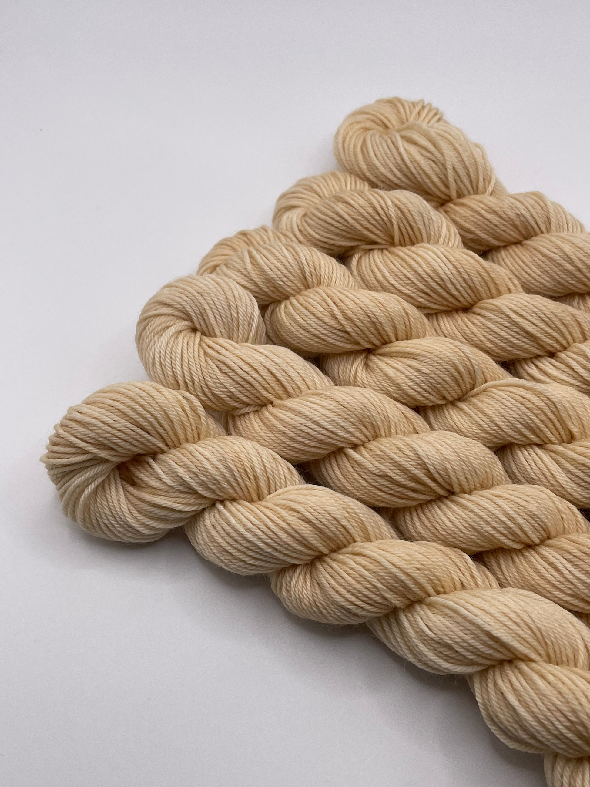 Cream yarn mini skeins on a white background