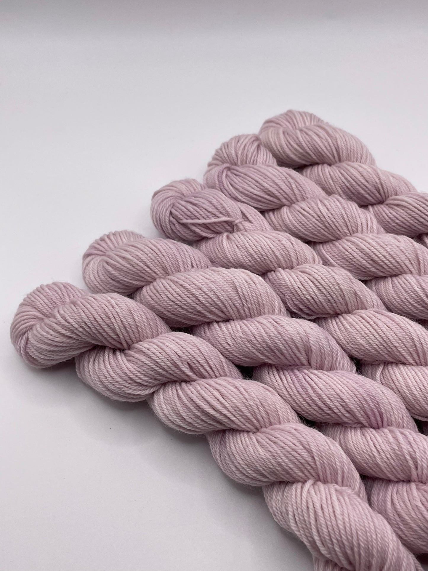 Pale purple yarn mini skeins on a white background