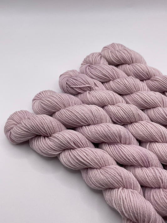 Pale purple yarn mini skeins on a white background